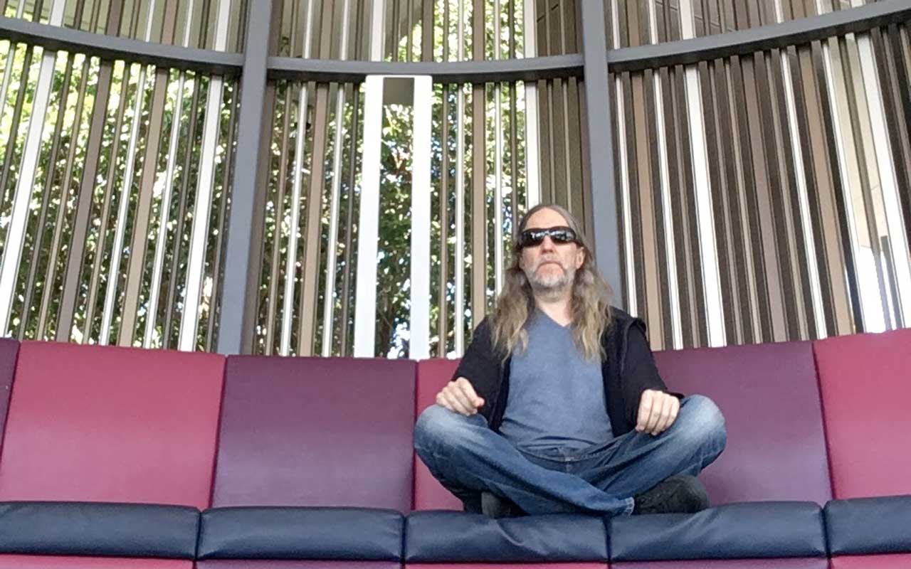 安东尼坐在他当地的大学校园冥想，练习可视化冥想。