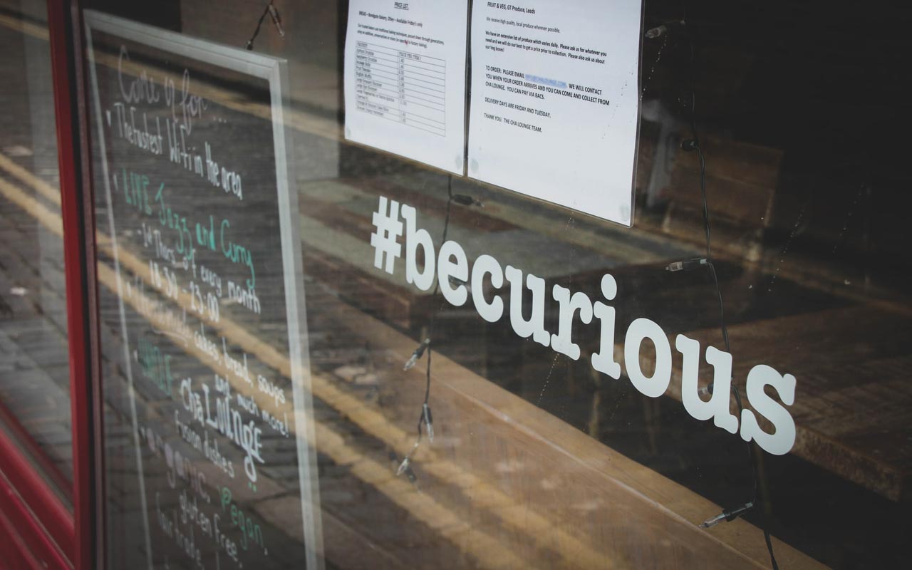 餐厅窗口中的一个图形读了“#becurious”