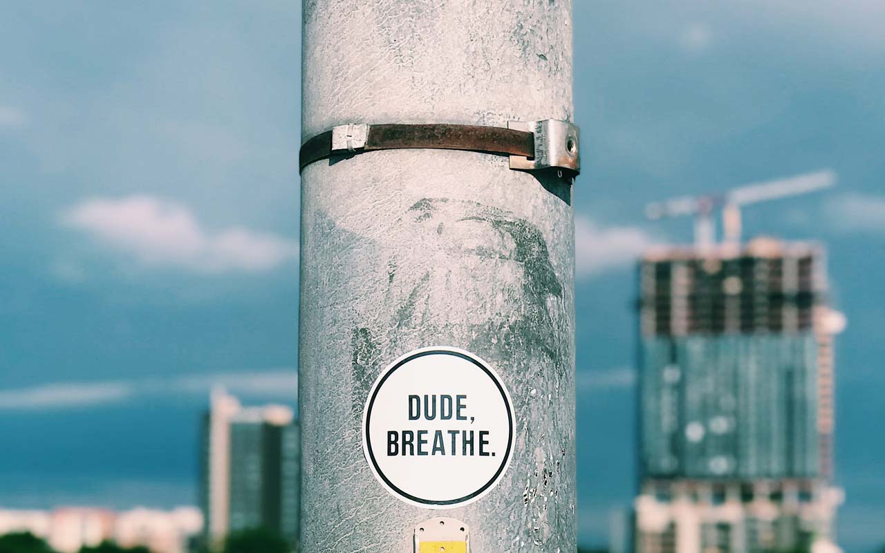 杆上的贴纸（俯瞰城市景观）读“Dude，呼吸”。