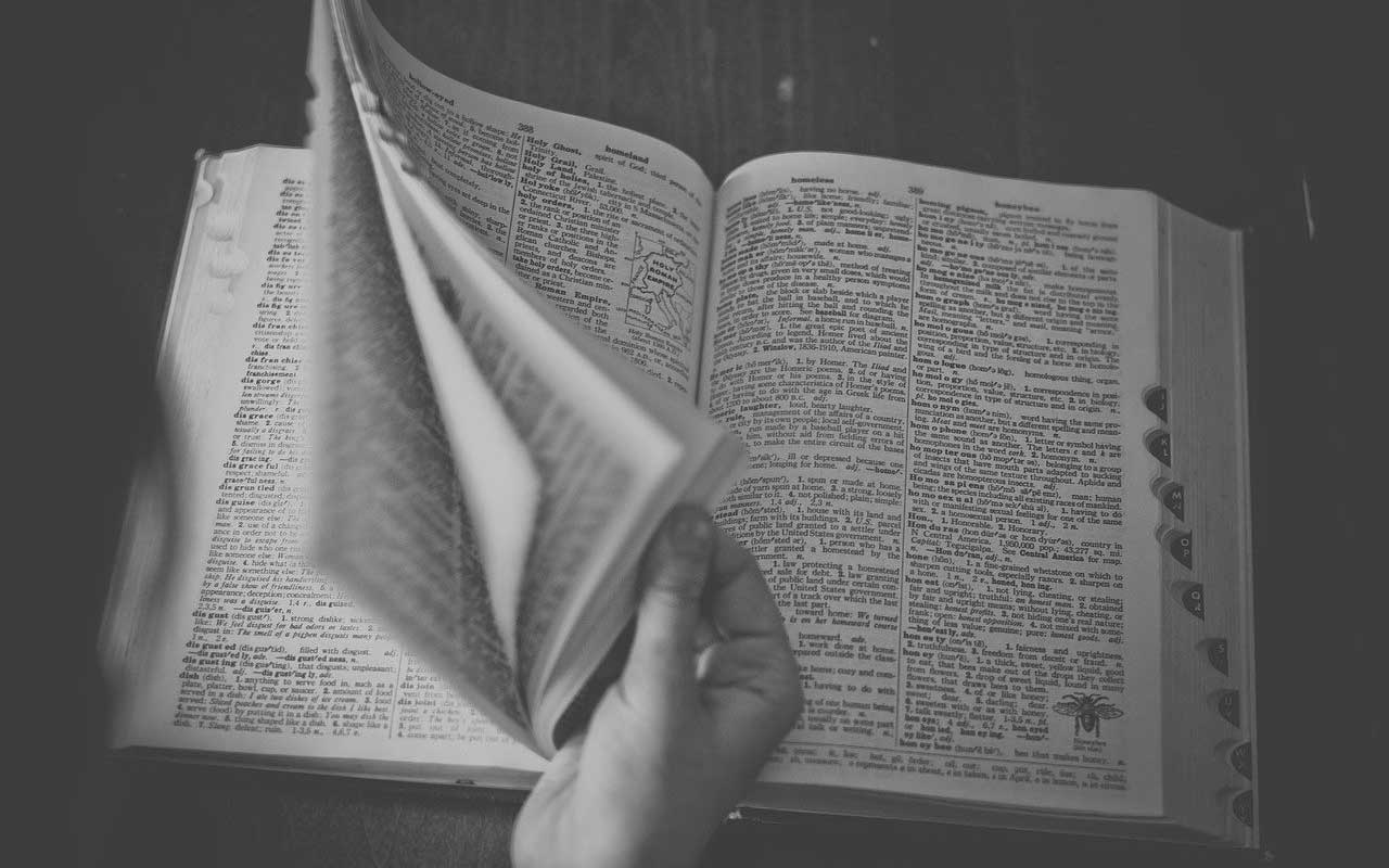 一个人翻阅一本大词典。拥有丰富的词汇量可以帮助你更快地思考。