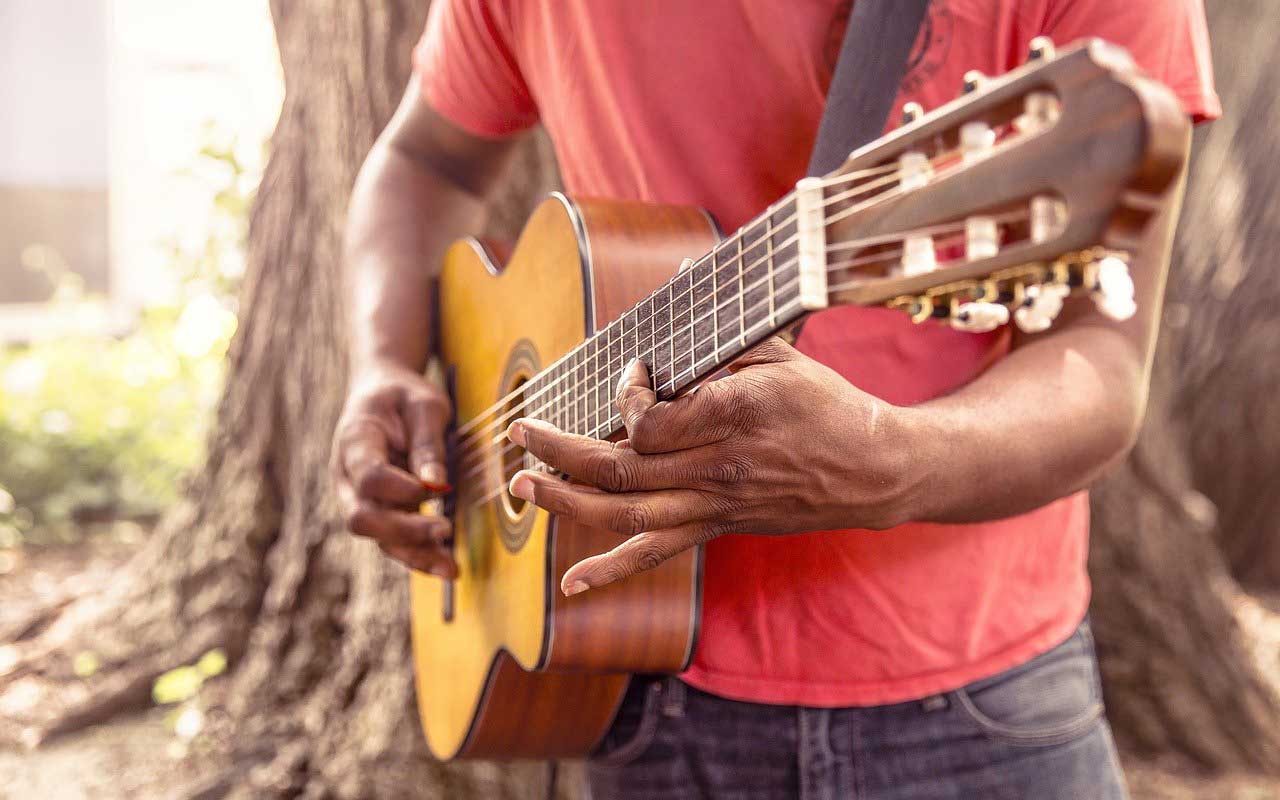 一个男人一边弹吉他一边学习如何背歌词。
