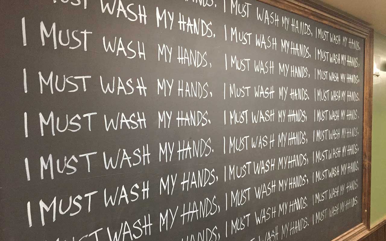 一个带有“我必须洗手”的黑板反复写。