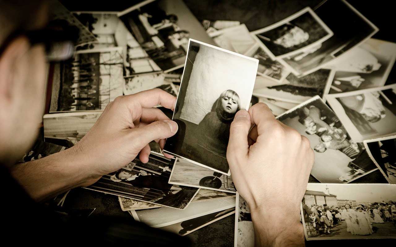 一个人拿着一张年轻女孩的旧照片。失忆症会让人甚至很难记住亲密的家庭成员。