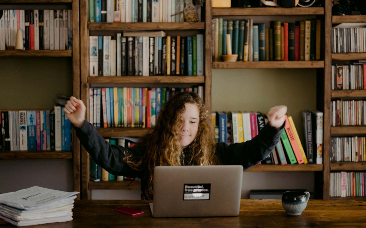 一名年轻女子在书架前的笔记本电脑前学习记忆技巧。
