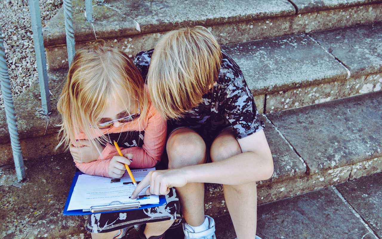 两个孩子一起学习，同时坐在步骤。