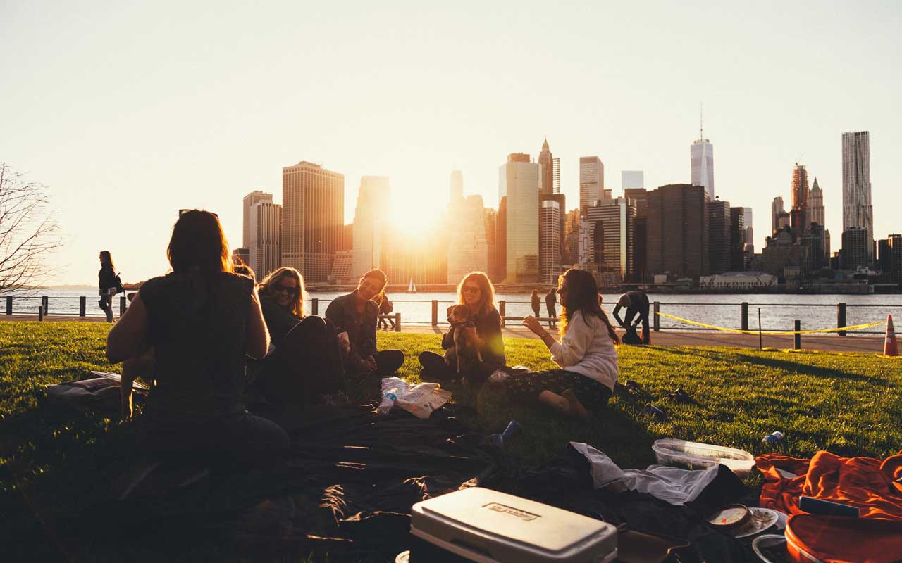 一群朋友旁边有一个户外野餐。与朋友交往对记忆有积极影响。