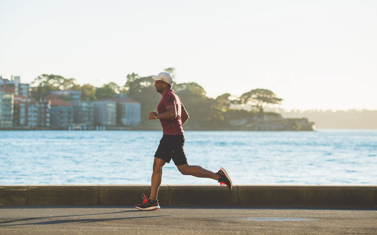 一个人沿着水体跑。通过定期锻炼来保持健康是你记忆策略的关键部分。