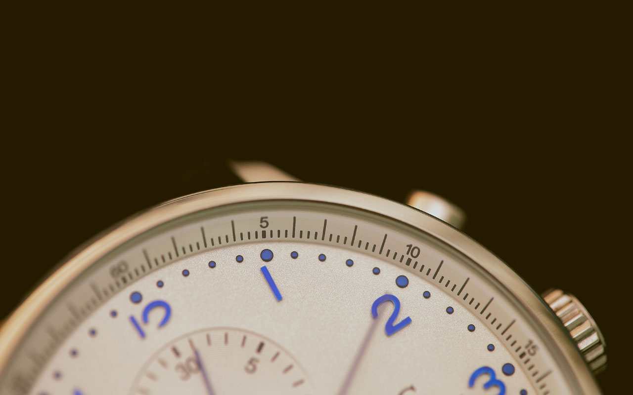 一个模拟时钟，镀金，表盘上的蓝色数字。