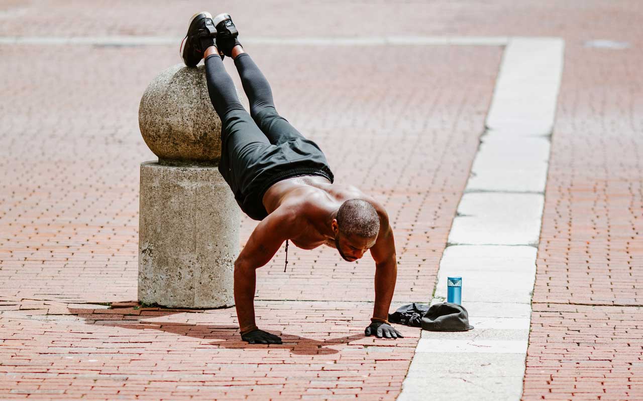 一个人确实在室外广场俯卧撑，用他的脚高架混凝土码头。运动是一种天然记忆增强剂。