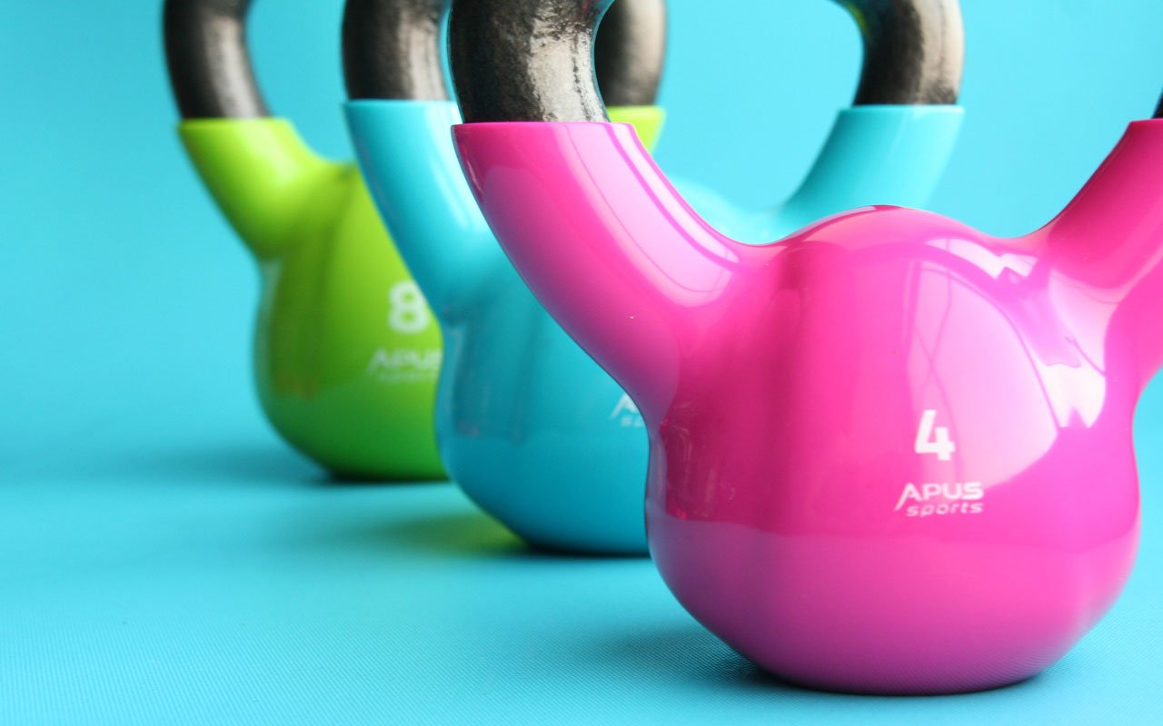 一套蓝色，绿色和粉红色的壶铃。运动可以帮助您记住更多。