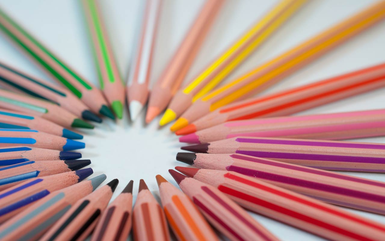 彩色铅笔的彩虹布置在一个圆圈中。颜色是您不需要在上下文中学习的语言学习词之一。
