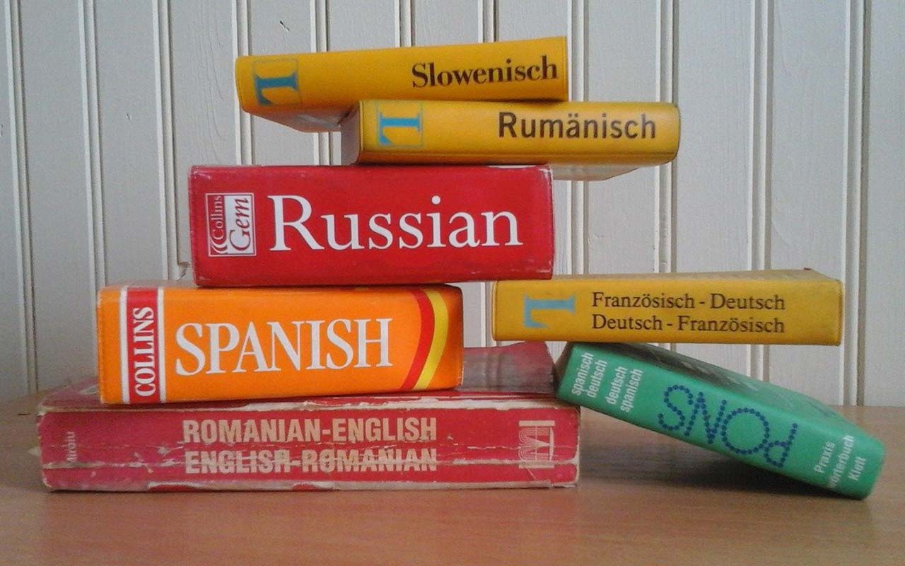 堆栈的俄语，西班牙语，罗马尼亚语和德语词典坐在桌子上。