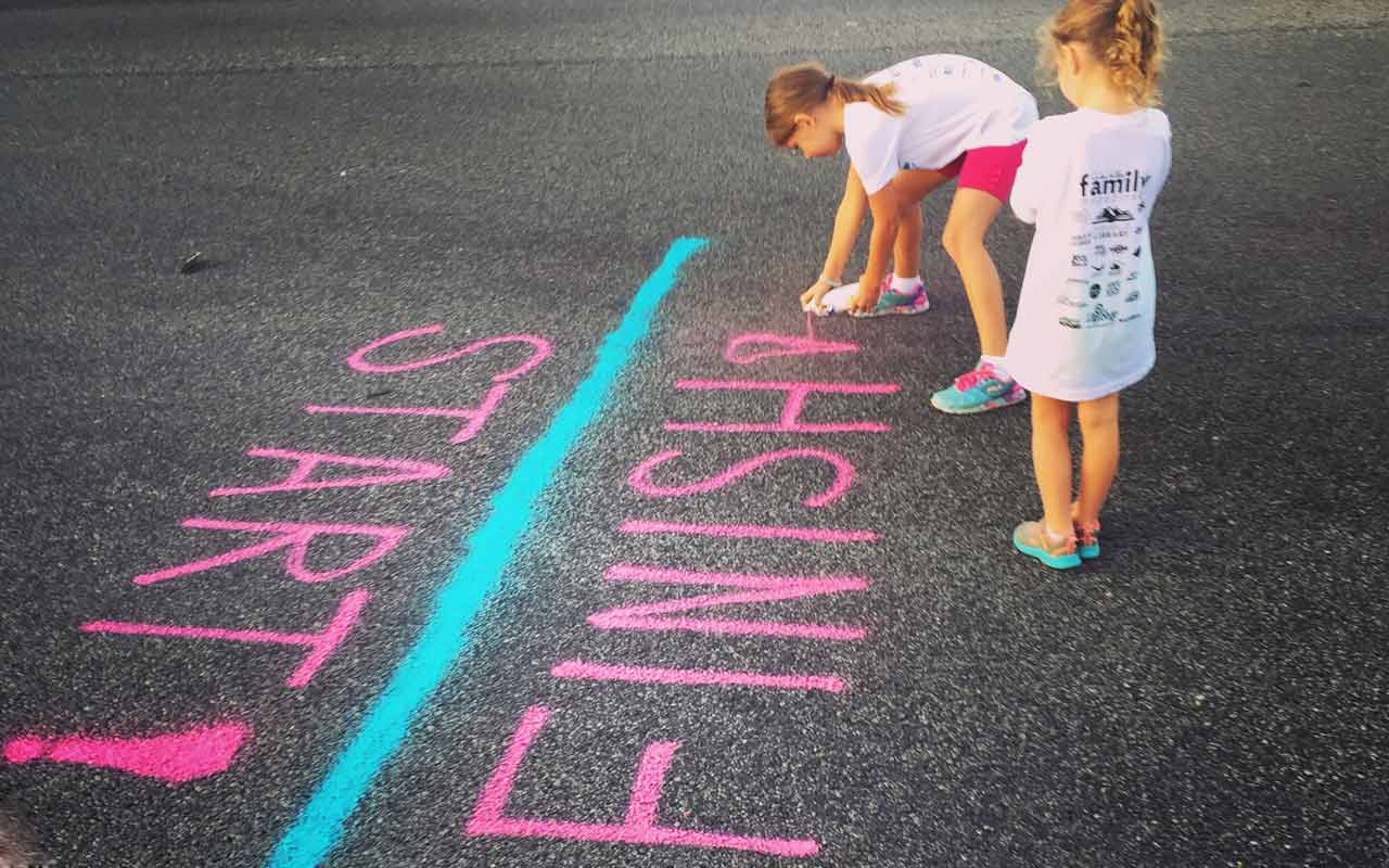 年轻女孩在人行道上画起跑线。