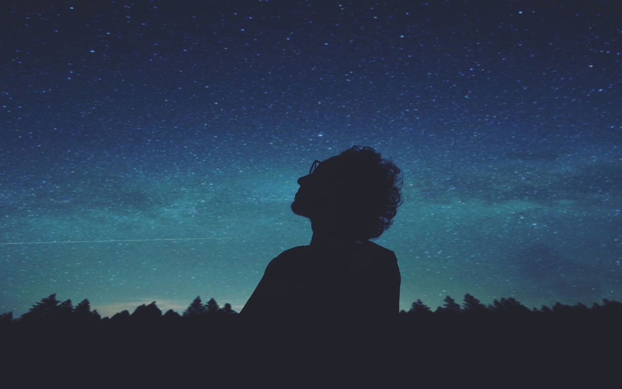 一个人盯着夜空满满的星星。更好的焦点可能是这种浓度冥想的结果。