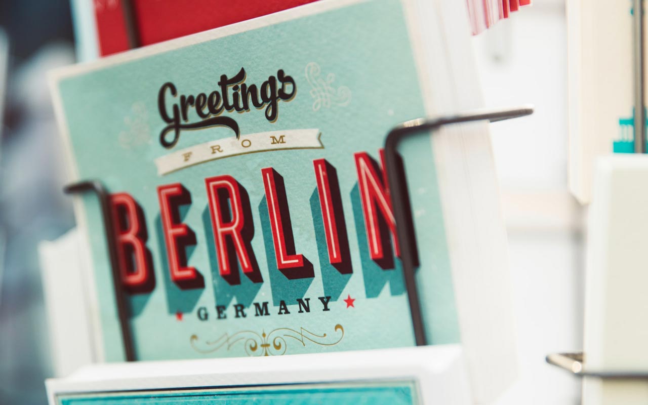 架子上放着一张明信片，上面写着“柏林问候”。德语是顶级商业语言之一。