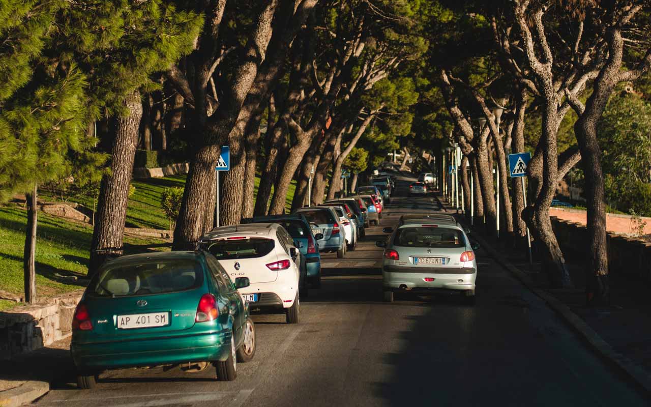 汽车停在绿树成荫的街道上。
