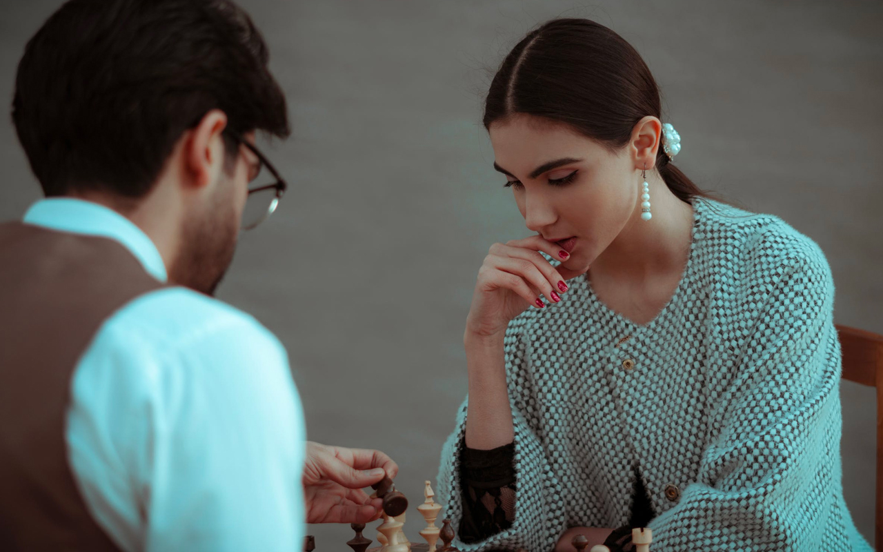 长头发的女人和戴眼镜的男人在下棋