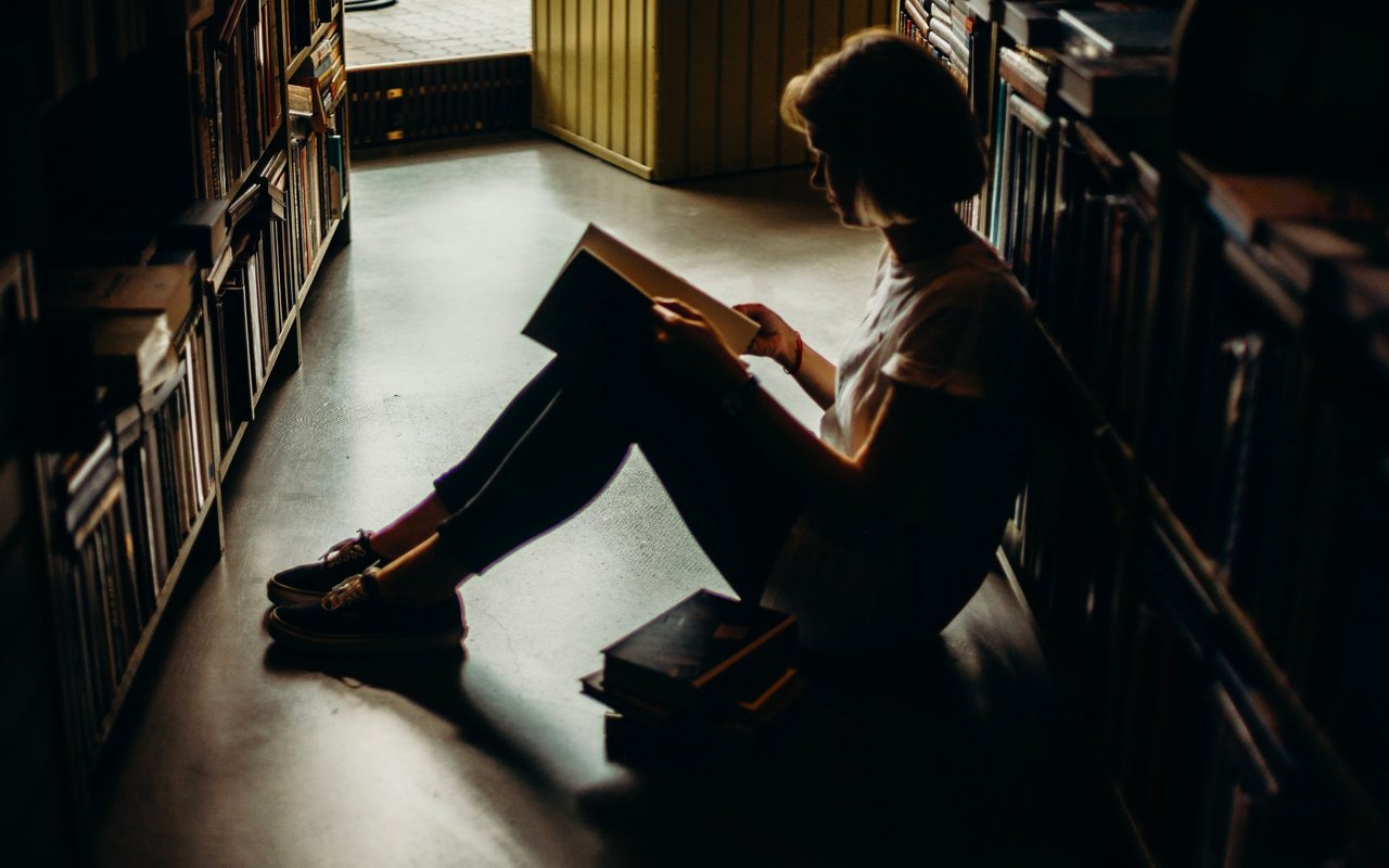 一个女人在图书馆的地板上看书