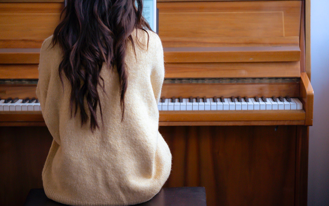 一个长发女人正在学钢琴